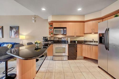 拉斯维加斯Royal Oasis Suite的厨房配有木制橱柜和不锈钢用具