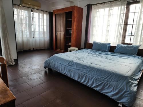 金边CHILCHILL Elite Residences BKK2的一间卧室配有一张带蓝色床单和窗户的床。