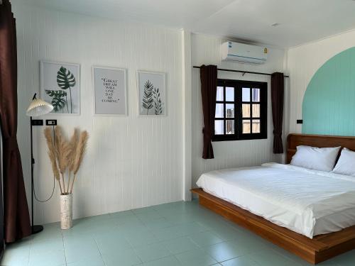 美翰Beach house in Chaloklum的白色的卧室设有床和窗户