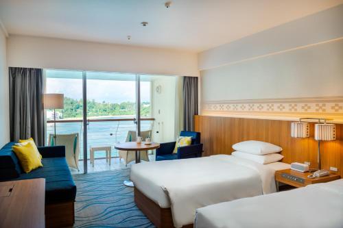 恩纳冲绳万丽度假酒店的酒店客房设有两张床和一个阳台。