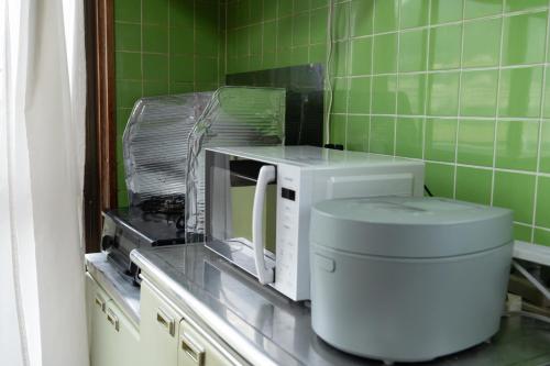 由布市【湯布院の山小屋】サンクラウド・ヒュッテ的厨房的台面上有一个微波炉