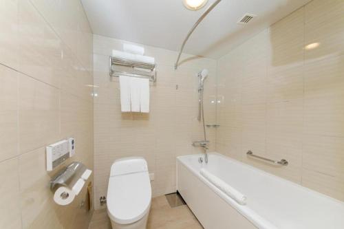 恩纳冲绳万丽度假酒店的浴室配有卫生间、浴缸和水槽。