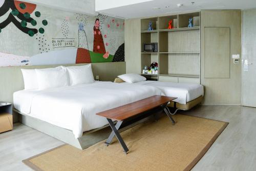 沙努尔ARTOTEL Sanur Bali的一间卧室设有两张床和一张木桌