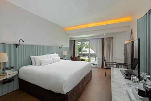 卡塔海滩The Boathouse Phuket - SHA Plus的酒店客房设有一张大床和一张书桌。