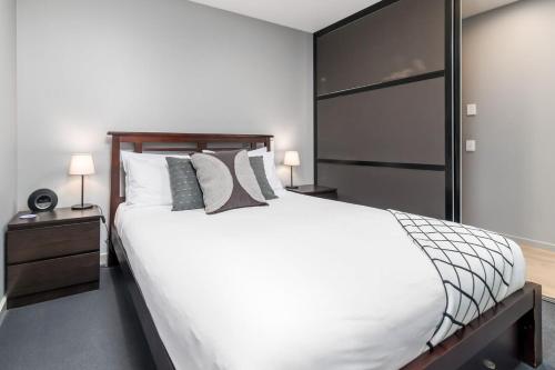 金斯顿Stunning 1BR Apartment with Water Views的卧室配有一张带白色床单和枕头的大床。