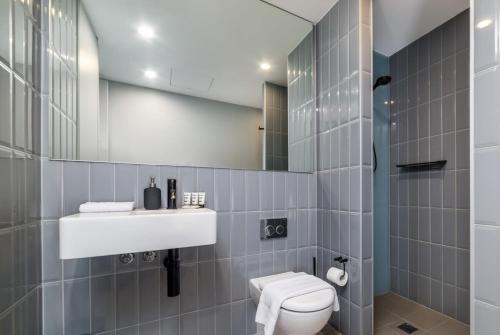 金斯顿Stunning 1BR Apartment with Water Views的一间带卫生间、水槽和镜子的浴室