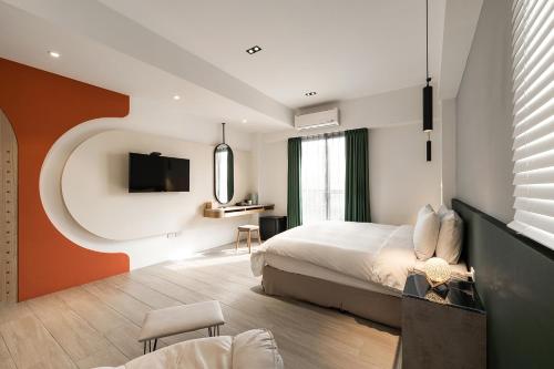 马公鹿角民宿的一间卧室配有一张床、一台电视和一把椅子