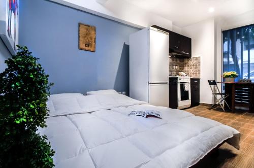 雅典Cozy Apartment in Athens 3 km from Acropolis, 5km form the beach的一张白色的大床,位于一个蓝色的墙壁上