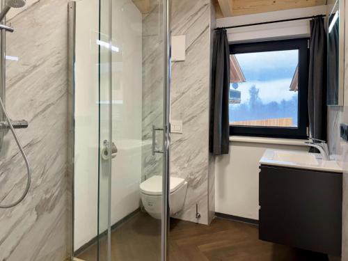 黑马戈尔Chalet near Nassfeld ski resort in Carinthia的带淋浴和卫生间的浴室以及窗户。
