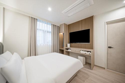 庆州Gyeongju Poverta Hotel的酒店客房,配有床和电视