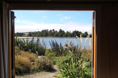但尼丁The Bird Hide - rustic luxury by the water的透过窗户可欣赏到湖景
