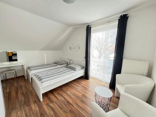 拉基兴Bogi's Ferienhaus - Pension的一间卧室配有一张床、一张书桌和一个窗户。