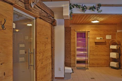 弗拉绍Aparthotel Paradies的一间带木墙和玻璃门的浴室