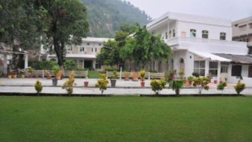 哈里瓦Hotel Bhajgovindam的前面有绿色草坪的大建筑