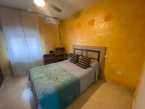 圣马丁德拉韦加Casa Pumba的一间卧室设有一张床和黄色的墙壁