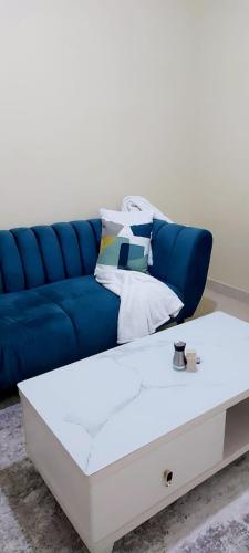 RuiruPetnah Apartments的蓝色的沙发和白色的茶几