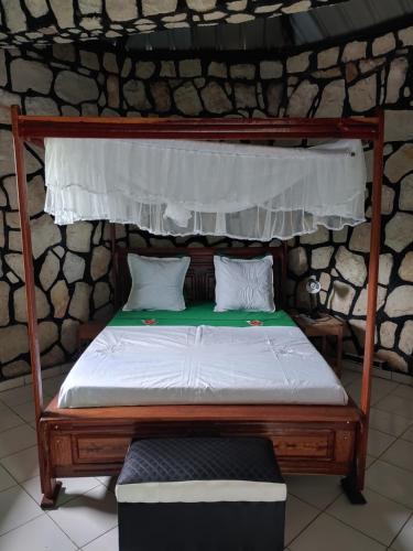 马哈赞加Châteaux Yolande的一张带木架和白色床垫的床