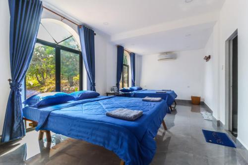 贡布Kampot Hill Lodge的带窗户的客房内的三张床