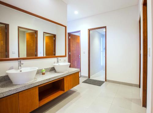 库塔Pudak Sari Unizou的浴室设有2个水槽和2面镜子