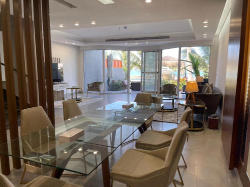 杜拉特阿拉尔فلل الغروب的客厅配有玻璃桌和椅子