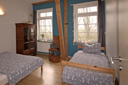 阿尔特费尔Ferienwohnungen Poppelvitz的一间卧室设有两张床和两个窗户。