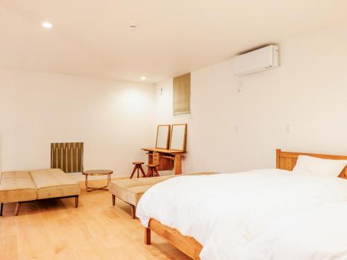长滨市AMAZING LIFESTYLE GLAMPING HOTEL - Vacation STAY 44042v的卧室配有白色的床和桌子