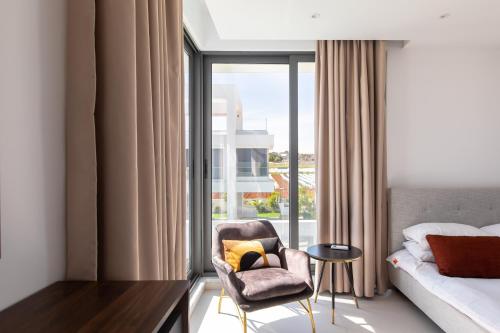 普罗塔拉斯Nelia Panorama Villa的卧室配有床、椅子和窗户。