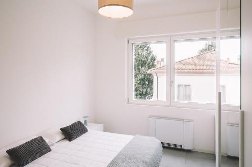 伊莫拉Appartamenti Autodromo的白色的卧室设有床和窗户