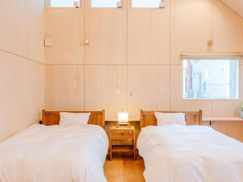 长滨市AMAZING LIFESTYLE GLAMPING HOTEL - Vacation STAY 48581v的带窗户的客房内的两张床