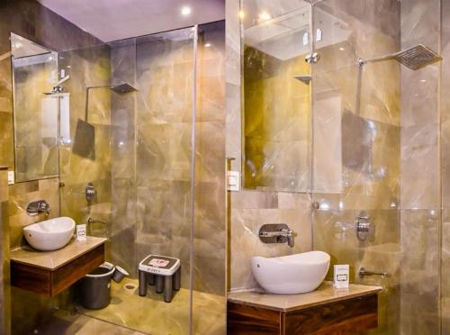 阿姆利则CJ国际酒店 的一间带两个盥洗盆和淋浴的浴室