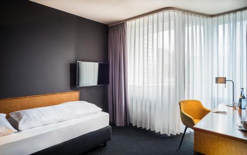 凯撒斯劳滕凯泽斯劳滕贝斯特韦斯特酒店的一间卧室配有一张床、一张书桌和一个窗户。