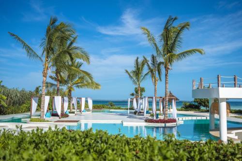 DikoniY Residential Luxury Villas的棕榈树和海滩的度假游泳池