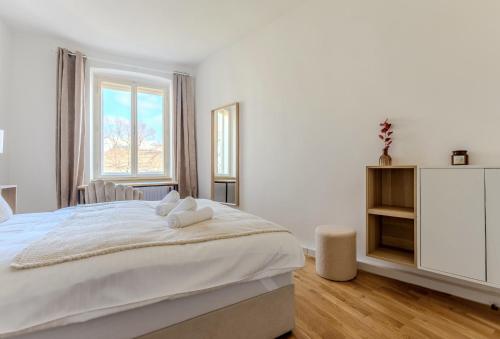 多瑙河畔克雷姆斯UrbanSuite in der Innenstadt的白色的卧室设有一张大床和一个窗户