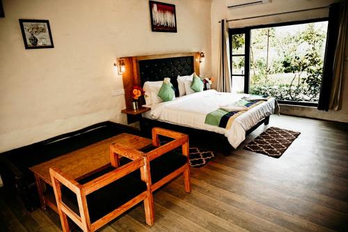 兰纳加Corbett Tiger Retreat的一间卧室设有一张大床和一个窗户。
