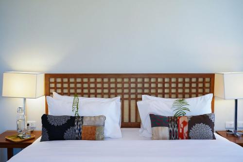 爱妮岛Pandan Villas, El Nido的一间卧室配有带白色床单和枕头的床。