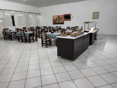 弗朗西斯科贝尔特朗PORTAL PARQUE HOTEL的用餐室配有桌椅和食物