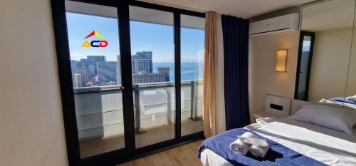 巴统Orbi City A - C - D的卧室设有大窗户,享有城市美景。