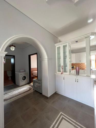 DelvinëVilla Kapllani的一间厨房,配有白色的橱柜和拱门