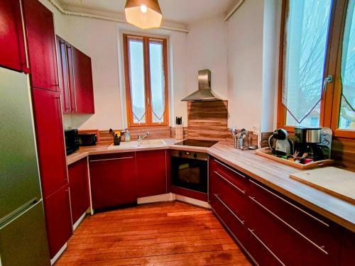 欧塞尔Home - L'Auxerroise - Séjour à Auxerre的一间带红色橱柜和水槽的厨房
