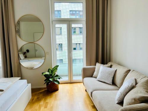 维也纳Zentrales Apartment mit Balkon的带沙发和镜子的客厅
