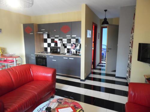绍德方丹西城旅馆的一间带红色沙发的客厅和一间厨房