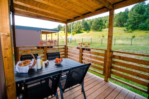 Donji Babin PotokBig Bear Plitvice Nature Resort的享有田野景致的甲板上的桌子