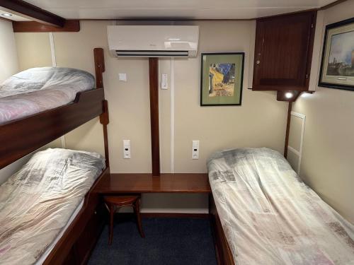 阿姆斯特丹Hotelboat Angeline的客房设有两张双层床和一张书桌。