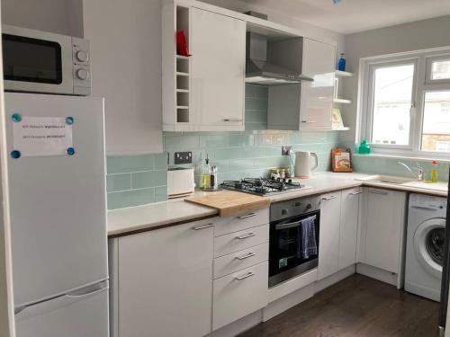 新港Modern home for those on business or on holiday的厨房配有白色橱柜和炉灶烤箱。