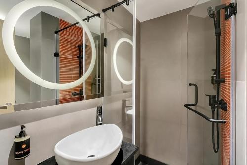 孟买Ginger Mumbai Airport的浴室设有白色水槽和镜子