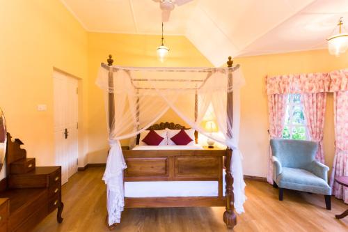 康提Rockbourne Bungalow的一间卧室配有天蓬床和蓝椅