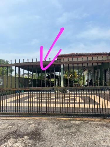 甲抛峇底Homestay Bajet Cikyah的建筑物前的栅栏上的一个粉红色x标志