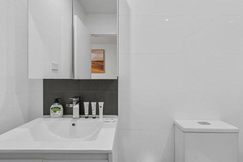 悉尼Modern Studio Retreat in Crown St with AirCon的白色的浴室设有水槽和镜子