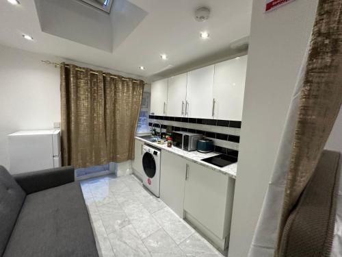 LewishamBeautiful Double Room with Free Wi-Fi and free parking的厨房配有白色橱柜、洗衣机和烘干机