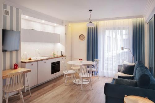 格丁尼亚I Love Gdynia Apartments - apartament z parkingiem的带沙发和桌子的客厅以及厨房。